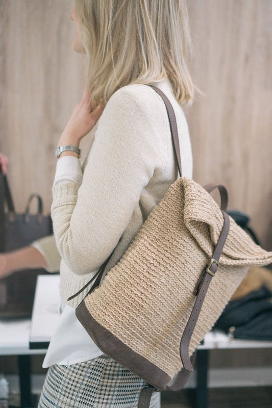 Woman wearing a jute and leather-trimmed backpack